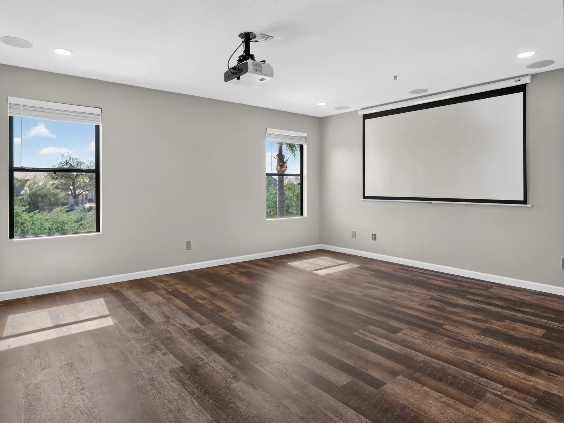 Empty media room vs virtually staged media room with sectional and projector screen — before