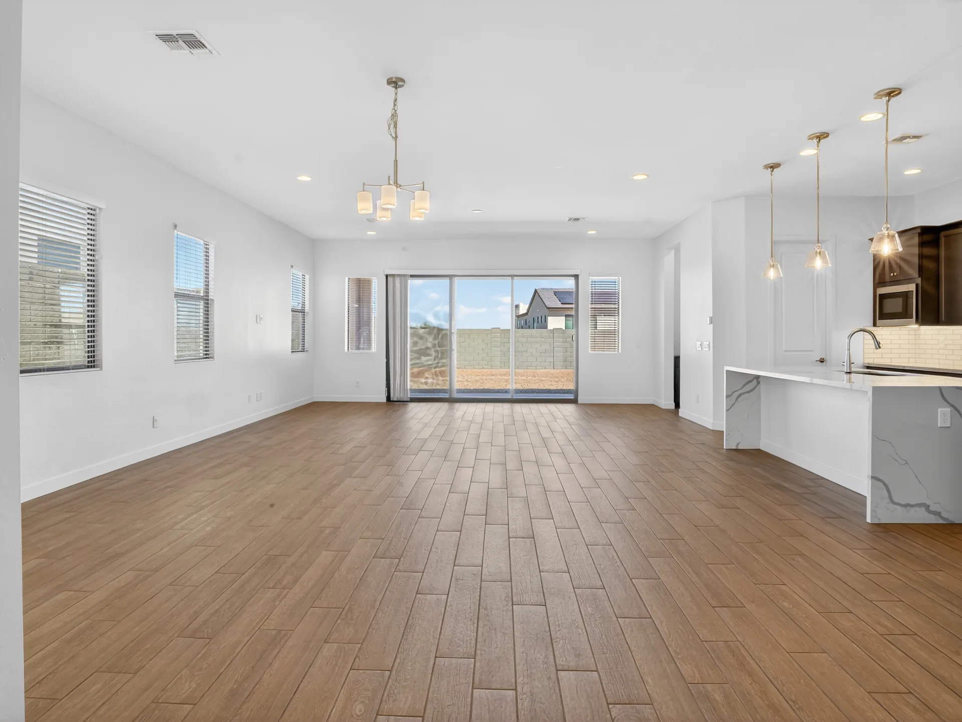 Empty great room vs virtually staged great room with kitchen and dining area — before